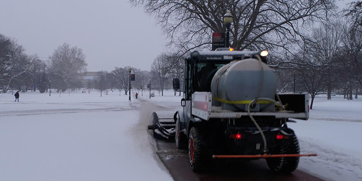 An FOD snow removal and pavement treatment vehicle on the oval removing snow.